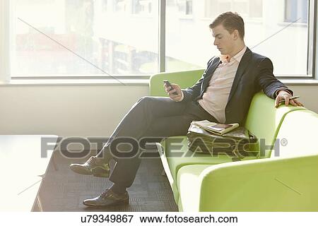 Businessman in departure lounge using cell phone View Large Photo Image Stock Photo - Businessman in departure lounge using cell phone. Fotosearch
