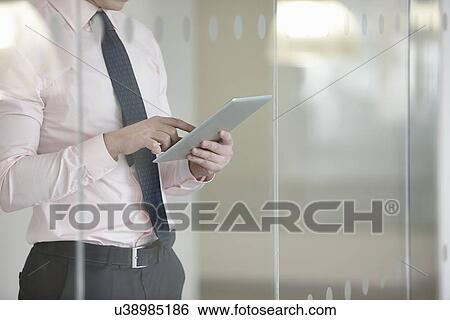 Businessman suing digital tablet View Large Photo Image Stock Photograph - Businessman suing digital tablet. Fotosearch