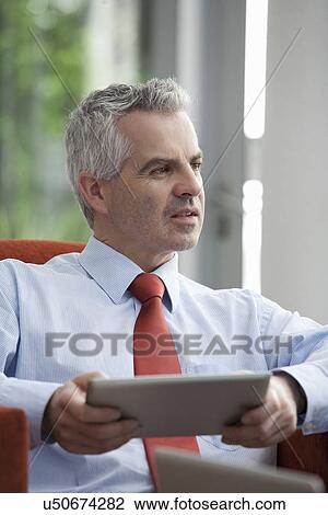 Stock Image - Businessman using digital tablet in office. Fotosearch