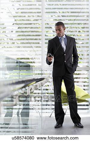 Businessman using texting on mobile phone in office View Large Photo Image Stock Image - Businessman using texting on mobile phone in office. Fotosearch