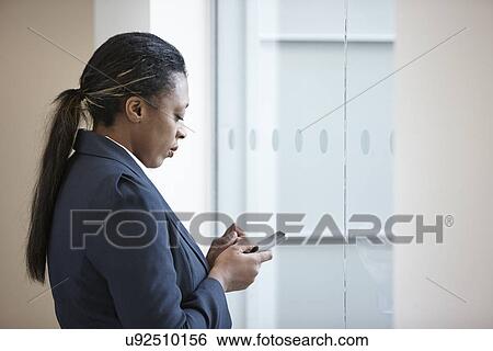 Stock Photograph - Businesswoman using cell phone. Fotosearch