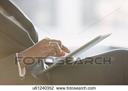 Stock Image - Businesswoman using digital tablet, close up. Fotosearch