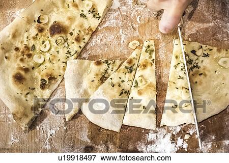 Chef's hand slicing pizza bread in commercial kitchen View Large Photo Image Stock Photo - Chef's hand slicing pizza bread in commercial kitchen. Fotosearch