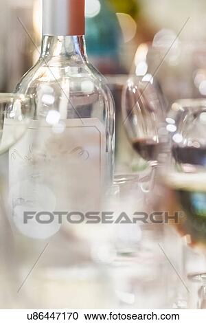 Stock Image - Close up of empty wine bottle and wine glasses. Fotosearch