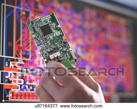 Stock Photo - Close up of engineer holding electronic circuitry for automotive use. Fotosearch
