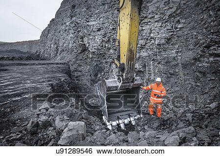 Stock Photograph - Coal miner inspects excavation in surface coal mine. Fotosearch