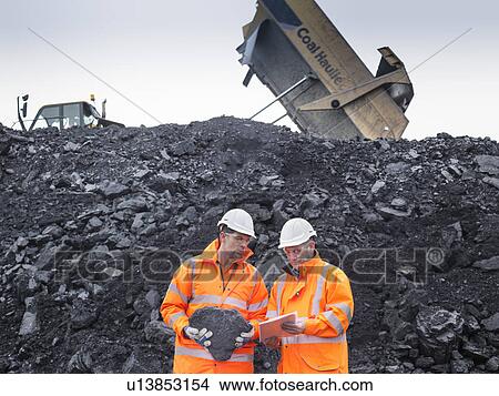 Picture - Coal miners inspecting coal in surface coal mine. Fotosearch