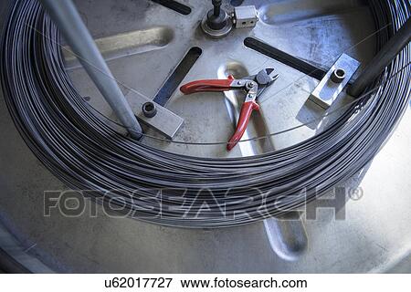 Coil of wire and wire cutters in factory View Large Photo Image Stock Photo - Coil of wire and wire cutters in factory. Fotosearch