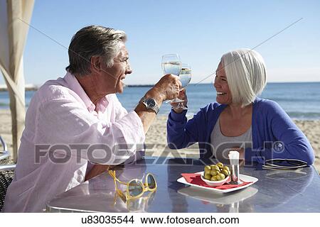 Couple enjoying wine by seaside View Large Photo Image Picture - Couple enjoying wine by seaside. Fotosearch