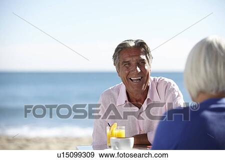 Stock Photo - Couple enjoying wine by seaside. Fotosearch