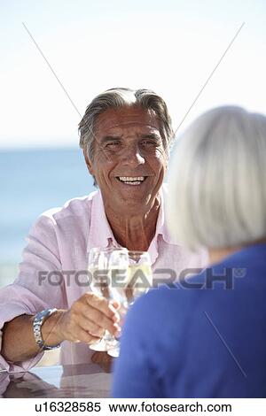Couple enjoying wine by seaside View Large Photo Image Stock Photography - Couple enjoying wine by seaside. Fotosearch