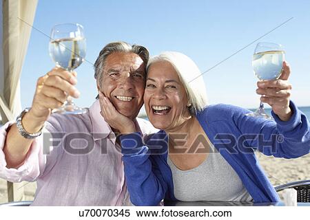 Stock Photography - Couple enjoying wine by seaside. Fotosearch