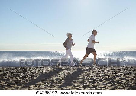 Stock Photo - Couple jogging on beach. Fotosearch