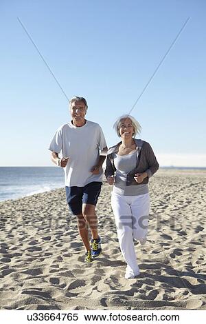 Stock Photography - Couple jogging on beach. Fotosearch