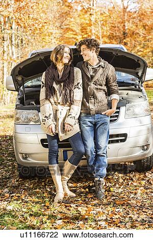 Couple leaning against car that has broken down View Large Photo Image Stock Image - Couple leaning against car that has broken down. Fotosearch