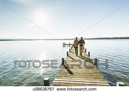 Stock Photo - Couple on jetty, Lake Starnberg, Bavaria, Germany. Fotosearch