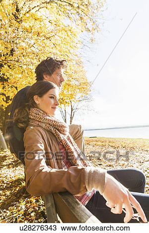 Stock Image - Couple sitting on bench. Fotosearch