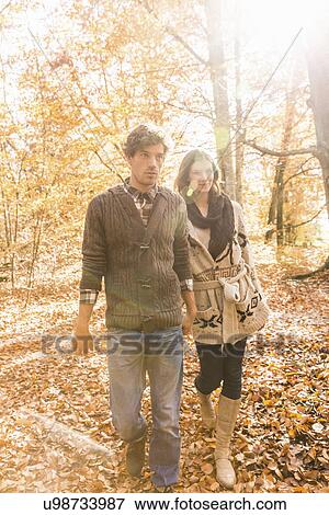 Couple walking in forest holding hands View Large Photo Image Stock Photo - Couple walking in forest holding hands. Fotosearch