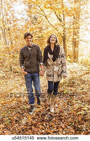 Stock Photography - Couple walking in forest holding hands. Fotosearch