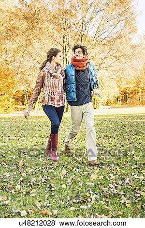 Couple walking in park View Large Photo Image Stock Photo - Couple walking in park. Fotosearch