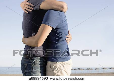 Cropped image of mature male couple hugging on beach View Large Photo Image Stock Image - Cropped image of mature male couple hugging on beach. Fotosearch