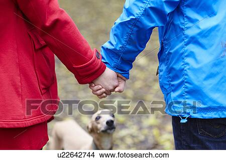 Cropped image of young couple and whippet View Large Photo Image Picture - Cropped image of young couple and whippet. Fotosearch