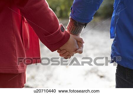 Cropped image of young couple holding hands View Large Photo Image Stock Image - Cropped image of young couple holding hands. Fotosearch