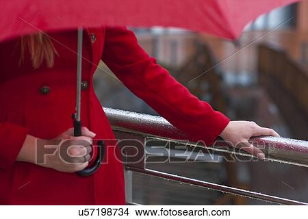 Cropped image of young woman in red carrying umbrella View Large Photo Image Picture - Cropped image of young woman in red carrying umbrella. Fotosearch