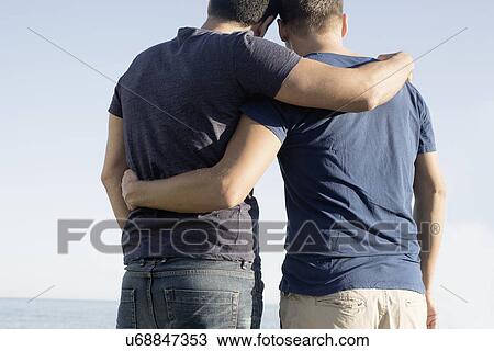Cropped shot of mature male couple with arms around each other at coast View Large Photo Image Stock Image - Cropped shot of mature male couple with arms around each other at coast. Fotosearch