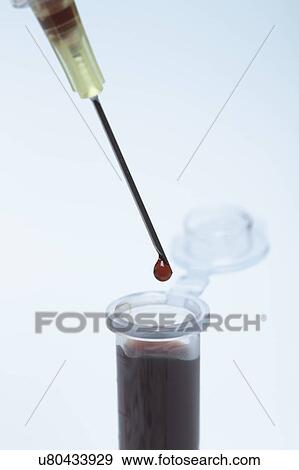 Stock Photo - Disposable plastic medical syringe dropping synthetic blood into microcentrifuge tube. Fotosearch