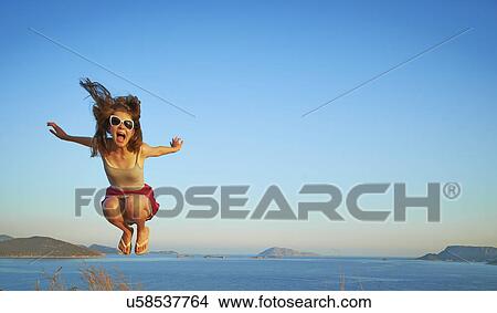 Energetic girl jumping mid air, Kas, Turkey View Large Photo Image Picture - Energetic girl jumping mid air, Kas, Turkey. Fotosearch