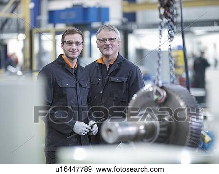 Engineer and apprentice with gear wheel at work station in factory, portrait View Large Photo Image Stock Photo - Engineer and apprentice with gear wheel at work station in factory, portrait. Fotosearch