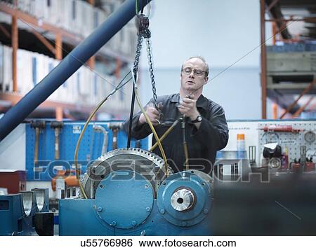 Stock Photograph - Engineer assembling industrial gearbox in engineering factory. Fotosearch