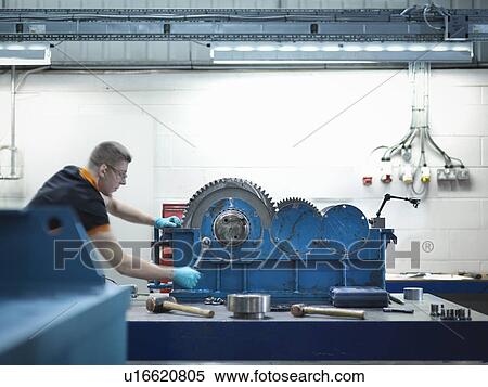 Stock Photography - Engineer assembling industrial gearbox in engineering factory. Fotosearch