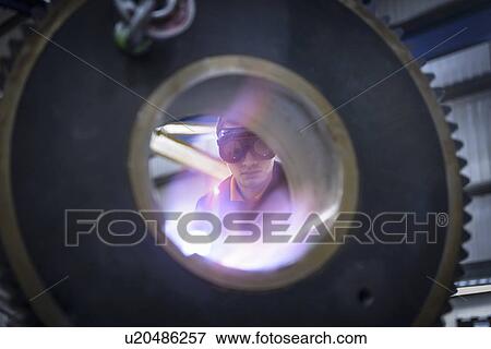 Engineer heat treats industrial gear in factory, close up View Large Photo Image Stock Photo - Engineer heat treats industrial gear in factory, close up. Fotosearch