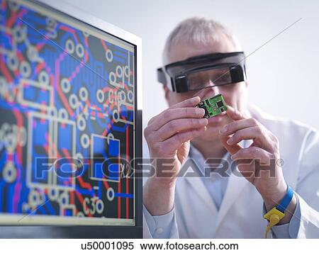 Stock Photography - Engineer inspecting electronic circuitry for automotive use. Fotosearch