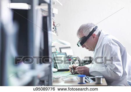 Engineer soldering prototype circuit board View Large Photo Image Stock Photograph - Engineer soldering prototype circuit board. Fotosearch