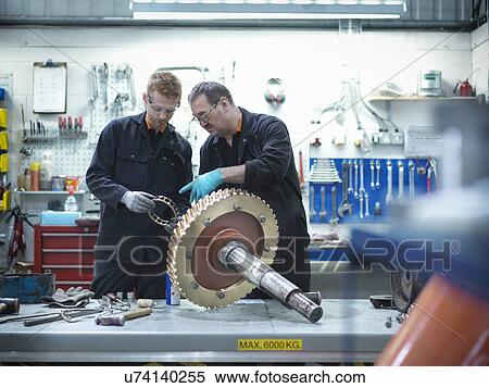 Engineer teaching apprentice in engineering factory View Large Photo Image Stock Photography - Engineer teaching apprentice in engineering factory. Fotosearch