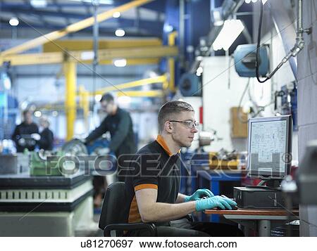 Engineer using computer in engineering factory View Large Photo Image Stock Photo - Engineer using computer in engineering factory. Fotosearch