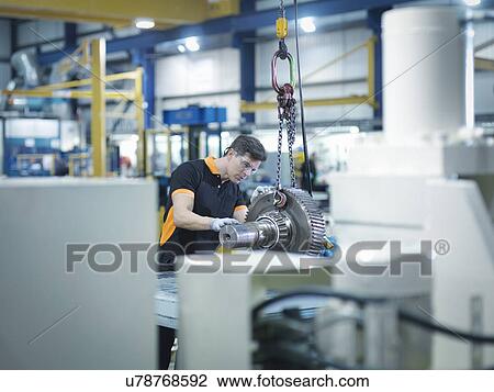 Engineer with gear wheel at work station in factory View Large Photo Image Stock Image - Engineer with gear wheel at work station in factory. Fotosearch