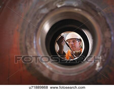 Stock Photo - Engineer working on excavator parts in surface coal mine. Fotosearch