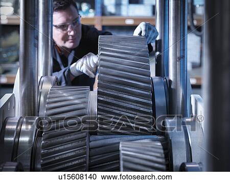 Stock Image - Engineer working on industrial gearbox. Fotosearch