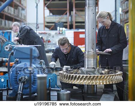 Stock Photography - Engineers assembling industrial gearbox in engineering factory. Fotosearch