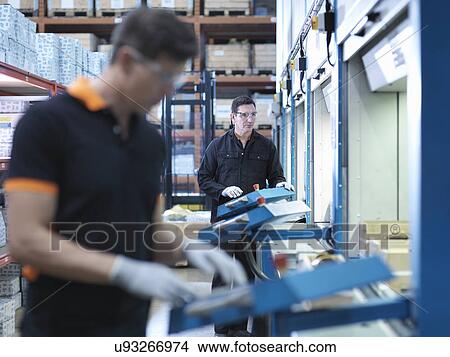 Engineers choose parts from automated store in factory View Large Photo Image Picture - Engineers choose parts from automated store in factory. Fotosearch