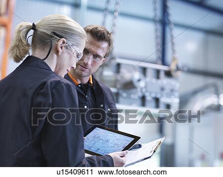 Engineers inspect plans on digital tablet in engineering factory View Large Photo Image Stock Image - Engineers inspect plans on digital tablet in engineering factory. Fotosearch