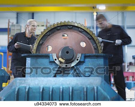 Stock Image - Engineers repair industrial gearbox in engineering factory. Fotosearch