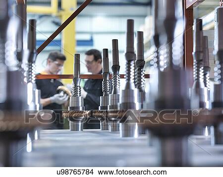 Picture - Engineers with parts in industrial gearbox factory. Fotosearch