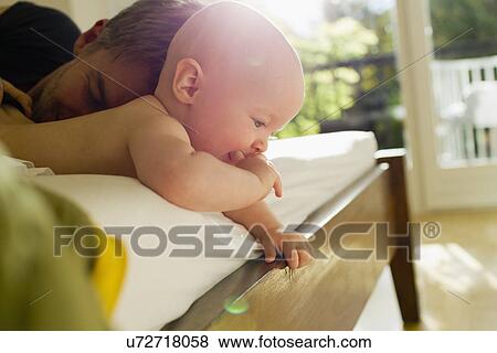 Father and baby daughter lying on bed View Large Photo Image Stock Photo - Father and baby daughter lying on bed. Fotosearch
