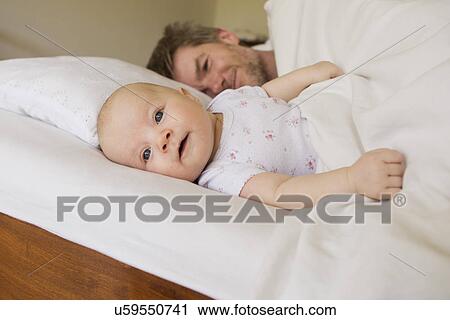 Father and baby daughter on bed View Large Photo Image Stock Image - Father and baby daughter on bed. Fotosearch