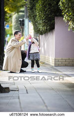 Picture - Father and daughter on pavement. Fotosearch